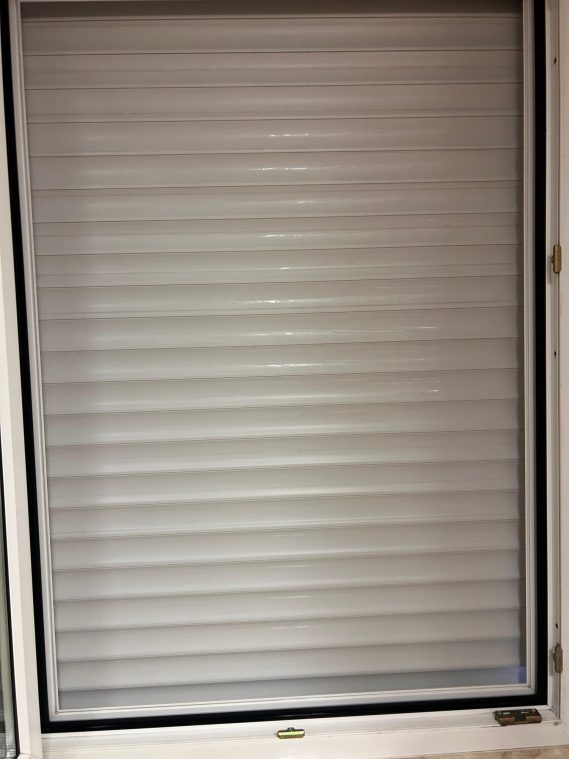 Fenster mit geschlossenem Rolladen und sauberen Lamellen