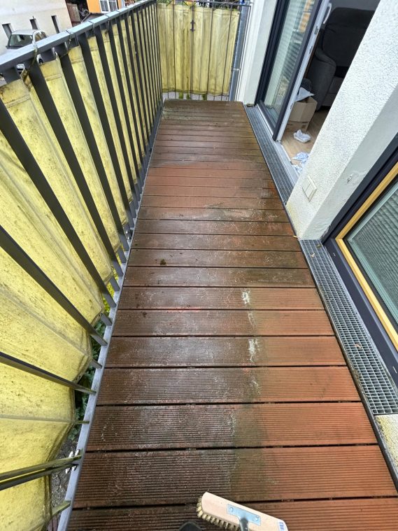 Balkon mit sauberem Holzboden mit Metall-Gelände